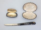 a knife and a shell shaped object on a table