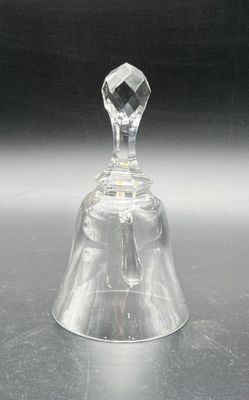 a clear glass bell on a table with a black background