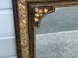 a mirror that has a bird on top of it