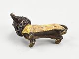bronze figurine of a dachshund dog on a white background