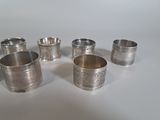 several silver cups are lined up in a row on a white surface