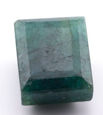 gros plan d'une pierre d'émeraude verte sur une surface blanche