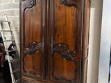 une armoire en bois avec des sculptures dans une pièce