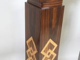 two wooden pedestals that have gold designs on them