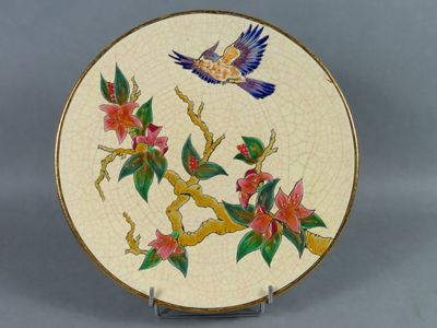 une assiette sur laquelle sont peints un oiseau et des fleurs