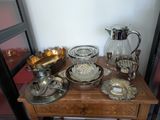 une petite table sur laquelle sont disposés de nombreux objets en argent et en verre