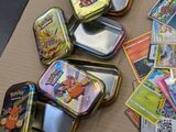 many tins of pokemon cards on the table