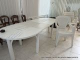 a white table and chairs in a room with blinds