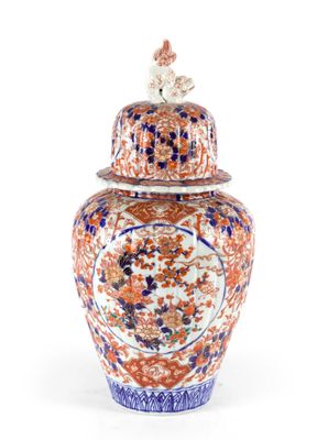 un vase orange et bleu posé sur une table blanche