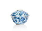 un vase bleu et blanc muni d'un couvercle, posé sur une surface blanche