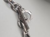 a silver chain with a key on it on a table