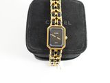 a close up of a watch on a black case with a chain around it