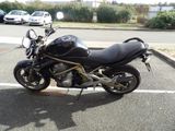 a black motorcycle parked in a parking lot next to some cars