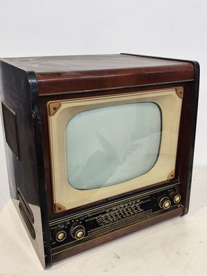 un téléviseur à l'ancienne posé sur une surface blanche