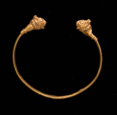 gros plan d'un bracelet en or sur fond noir