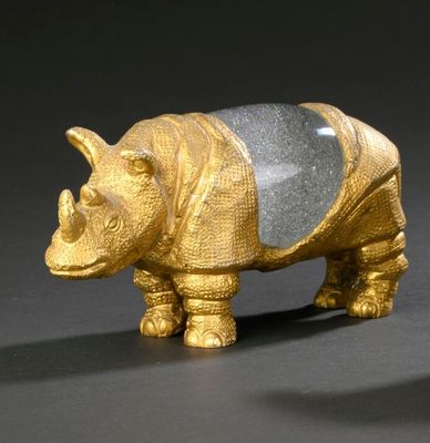 a gold rhino figurine on a black background