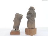 two statues of a man and a woman on wooden stands