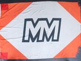un drapeau orange et blanc sur lequel figure le logo « m m »