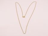 un collier en or avec un pendentif en forme de cœur sur fond blanc