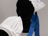 pair of white bonnets with blue ribbon and lace