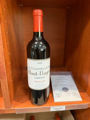 une bouteille de vin posée sur une étagère à côté d'un livre