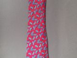 pink and blue paisley necktie on a gray background