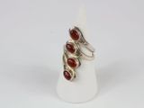 a close up of a silver ring with red stones on it