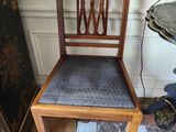 a wooden chair with a blue seat next to a small table