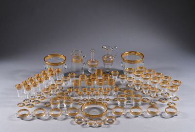 an assortment of gold and clear glass items on a white surface