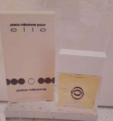 un flacon de parfum et un coffret de parfum posés sur un comptoir devant un miroir