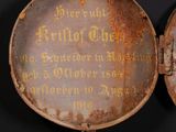 an old, rusted, metal pocket with writing on the inside of it