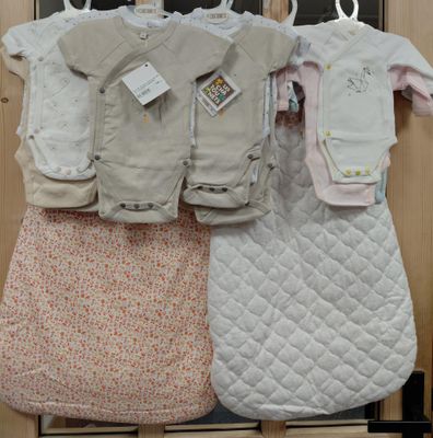 plusieurs vêtements pour bébé suspendus à un portant devant une porte