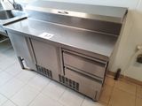 une cuisine en inox équipée d'un évier et d'un réfrigérateur