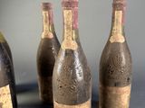 four bottles of wine are lined up on a table