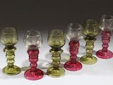 six verres à vin sont alignés sur une surface blanche