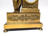 a gold clock with a statue on top of it