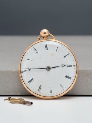 a gold pocket watch with roman numerals on it