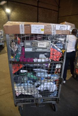 a large metal cart with many items on it in a warehouse