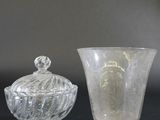 two glass vases sitting on top of a table next to each other