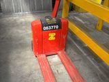 a red fork lift truck parked in a warehouse