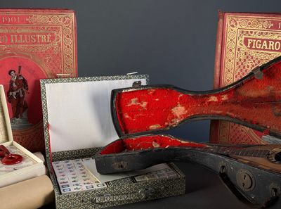 un étui de guitare rouge posé à côté d'une paire de ciseaux et d'une paire de ciseaux