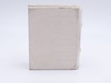 a small white book sitting on top of a white table