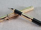 two pens sitting on top of a table next to each other