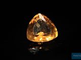 un diamant jaune sur une surface noire, avec un fond noir