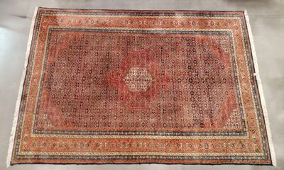a red rug with a medallion design on it on a white floor