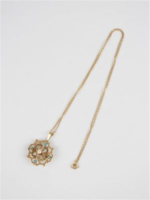 un collier en or et turquoise orné d'un pendentif en forme de fleur