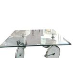a glass coffee table with wheels and a glass top