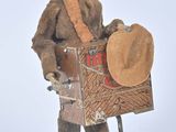 un jouet en bois représentant un homme avec un chapeau et un panier