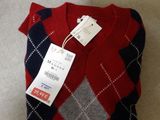 the sweater is red, blue, and grey with a tag on it