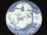 une assiette bleue et blanche ornée d'un oiseau et de fleurs